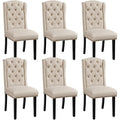 Lot de six chaises en tissu beige effet lin, dossier capitonne, pieds en bois massif et details clous dores